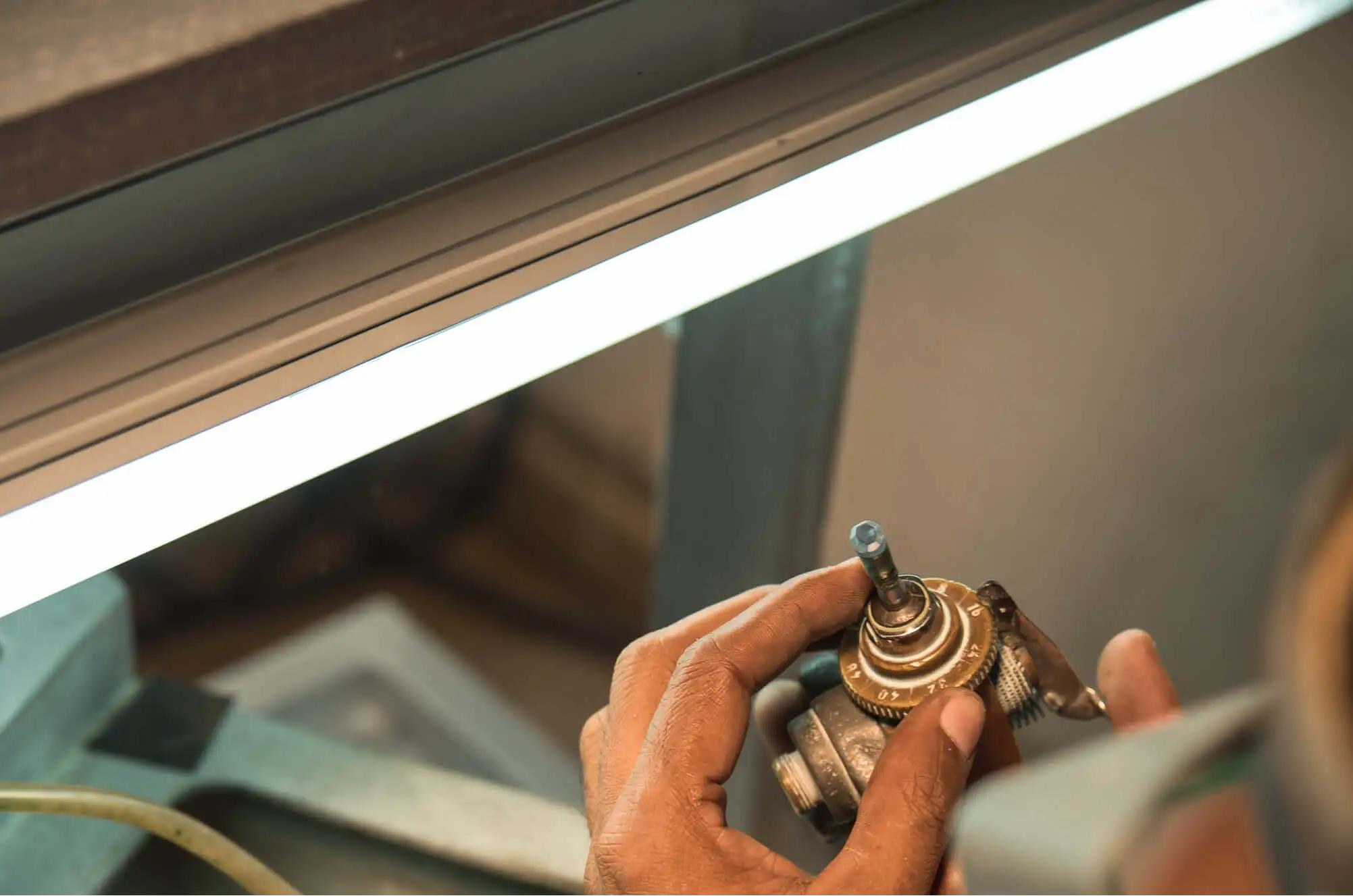 A cutter adjusting the index setting on a faceting machine